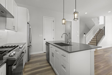 a kitchen with white cabinets and a black counter top